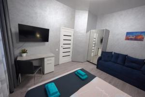 een woonkamer met een blauwe bank en een bureau bij New cozy apartment near Opera House and “Malevich” in Lviv