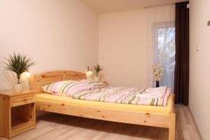 a bedroom with a wooden bed and a window at Aba Sea House in Balatonszárszó