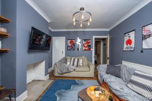 a living room with blue walls and a couch at The Victorian Getaway - Central in Canterbury