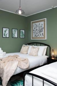 Dos camas en un dormitorio con paredes verdes. en The Victorian Getaway - Central, en Canterbury