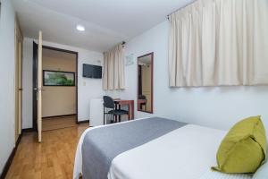 Cette chambre comprend un lit et un bureau. dans l'établissement Ayenda Aragon, à Manizales