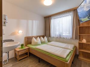 sypialnia z łóżkiem, umywalką i oknem w obiekcie Ferienhaus Zimmereben w Mayrhofen