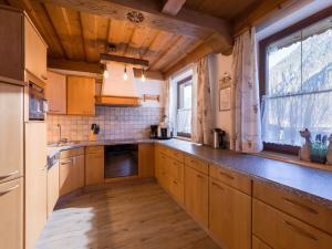 a kitchen with wooden cabinets and a large window at Ferienhaus Zimmereben in Mayrhofen