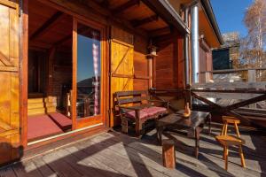 a porch of a log cabin with a bench and a chair at HostGost Mountain Houses - Vila Zarić in Kopaonik