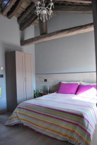 sypialnia z dużym łóżkiem z różowymi poduszkami w obiekcie b & b Alle 3 palme w mieście San Giórgio di Nogaro