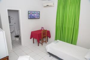 una habitación con una mesa y una cortina verde en Hotel Euzebio´s en Boa Vista