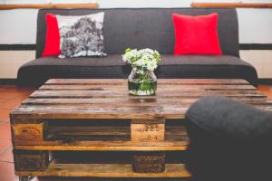 a wooden coffee table with a vase of flowers on it at Sintra1012 Boutique Guesthouse in Sintra