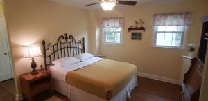 a bedroom with a large bed and two windows at Miller-Dunham House B&B in Middletown