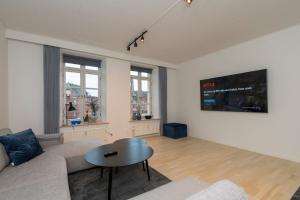- un salon avec un canapé et une table dans l'établissement Modern Luxury Penthouse, à Sønderborg