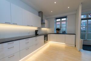 a large kitchen with white cabinets and black counter tops at Modern Luxury Penthouse in Sønderborg