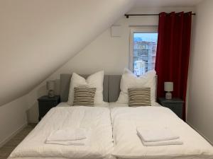 1 dormitorio con 2 camas y cortina roja en Niwas Apartments, en Fulda