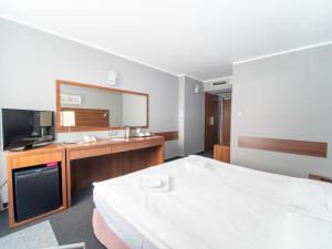 um quarto de hotel com uma cama e uma televisão em Hotel Tychy em Tychy