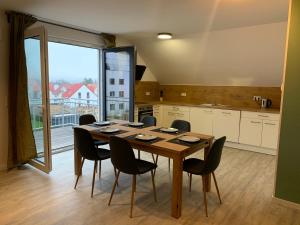 mesa de comedor con sillas y ventana grande en Niwas Apartments, en Fulda