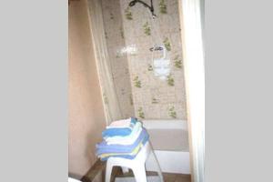 a bathroom with a white tub and a stool with towels at Studio dans station de ski aux pieds des pistes in Selonnet