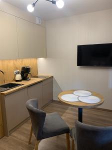 a kitchen with a table and two chairs and a table at Kurort Kozubnik Apartament 12 in Porąbka
