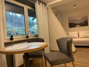 a room with a table and two chairs and a window at Kurort Kozubnik Apartament 12 in Porąbka