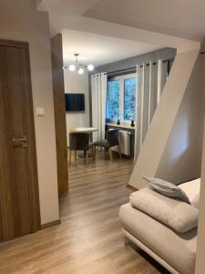 a room with a bed and a table and a window at Kurort Kozubnik Apartament 12 in Porąbka