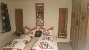 1 Schlafzimmer mit 2 Betten mit roten und weißen Kissen in der Unterkunft Chalet Waldperle in Arosa