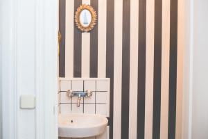 a bathroom with a sink and a mirror on a striped wall at Sintra1012 Boutique Guesthouse in Sintra +35 photos