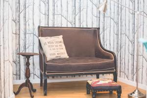 a brown chair in a room with a forest wallpaper at Sintra1012 Boutique Guesthouse in Sintra