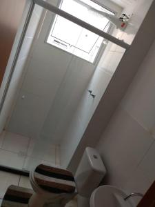 a bathroom with a toilet and a skylight at Apartamento Gaia in Campos dos Goytacazes
