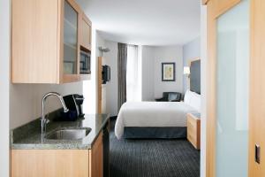 a hotel room with a bed and a sink at Club Quarters Hotel World Trade Center, New York in New York