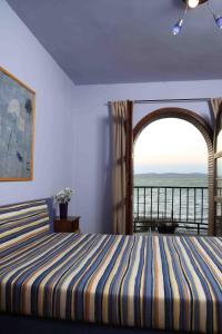 a bedroom with a bed and a large window at Aba Beach House in Balatonszárszó