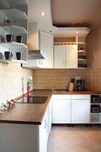 a kitchen with white cabinets and a counter top at Aba Beach House in Balatonszárszó