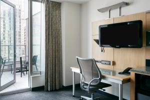 a hotel room with a desk and a tv at Club Quarters Hotel World Trade Center, New York in New York