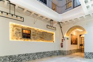 Habitación con una pared de piedra y un cuadro en la pared. en Fabio Catedral I, en Cádiz