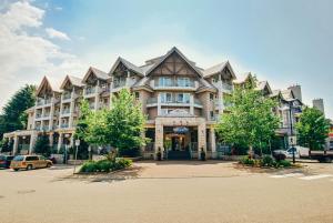 a large building with a clock on the front of it at Summit Lodge Boutique Hotel Whistler in Whistler