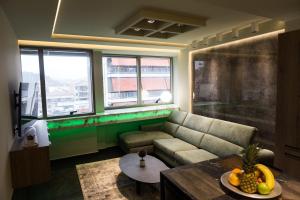 a living room with a couch and a table at ASKLIPIOS LUXURY SUITE in Tríkala
