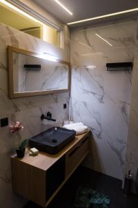 a bathroom with a sink and a mirror at ASKLIPIOS LUXURY SUITE in Tríkala