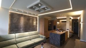 a living room with a couch and a kitchen at ASKLIPIOS LUXURY SUITE in Tríkala