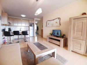 a living room with a table and a kitchen at Well refined apartment - stunning pool in Palm-Mar