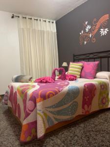 een slaapkamer met een bed met een kleurrijke deken bij Vivienda Vacacional C & M in Puerto del Rosario