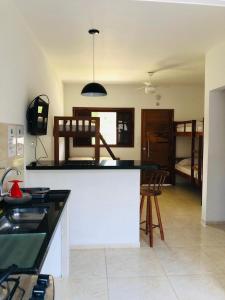 uma cozinha com um balcão e um quarto com uma cama em Villa Palmeira Ubatuba em Ubatuba