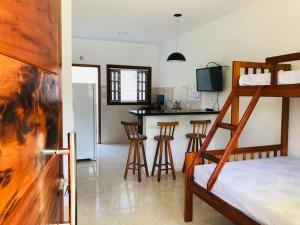 um quarto com um beliche e uma cozinha com um bar em Villa Palmeira Ubatuba em Ubatuba