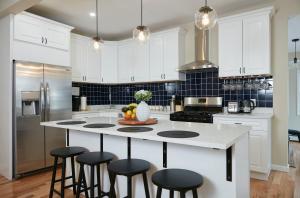 a kitchen with white cabinets and a island with bar stools at Chateau Lodge - Ski Shandaken, Hunter, Catskills, Windham, Belleayre in Shandaken