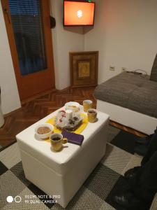 una habitación con una mesa con un pastel y tazas en ella en Apartman Zubac, Vrnjacka Banja, en Vrnjci