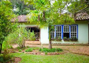 a house with a window and a tree in the yard at Casa Verde-Casa de Temporada no Bichinho in Bichinho