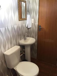 a bathroom with a toilet and a sink at Pousada Mont Hebrom in Ibicoara