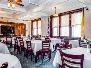 una sala da pranzo con tavoli e sedie bianchi di Leo House a New York