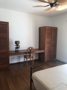 Schlafzimmer mit einem Schreibtisch, einem Bett und einem Ventilator in der Unterkunft Amigo 2 in Cap Skirring