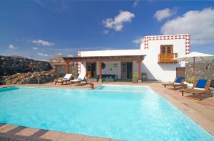 een villa met een zwembad en een huis bij Casa Rural Hero in Tías