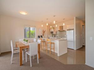 cocina y comedor con mesa y sillas en Lakeside Villa Retreat - Matarangi Downstairs Unit, en Matarangi