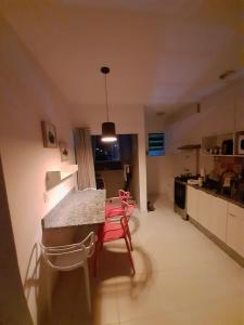 a kitchen with a table and chairs in a room at APTO PERTINHO DA PRAIA - Lindo e Equipado! Internet 400mb e 3 Tvs - Completo! TV a Cabo in Ubatuba