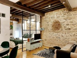 a living room with a stone wall and a bedroom at Lofts amantes de Toledo- LOFT ALCAZAR in Toledo