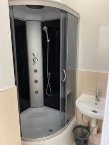 a shower with a glass door next to a sink at Хостел Мажор in Kharkiv