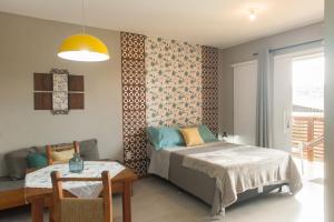 Un dormitorio con una cama y una mesa y un comedor. en LAS ROZAS Parador, en Praia do Rosa 30 fotos más